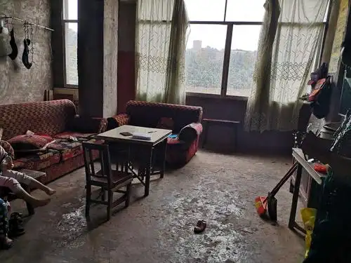 简陋的房间,一张桌子,几把椅子,破旧的沙发,一台电视,这就是他家里的