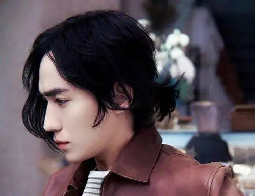 给男生带来了很强烈的时尚感,男生露额头扎低马尾辫发型,是用了蓬松感