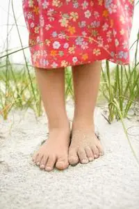 在沙子里的小女孩脚照片