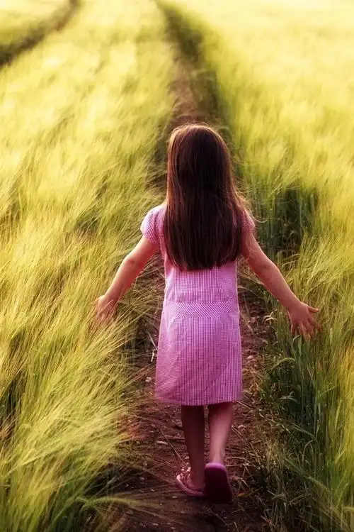 小女孩走在田野的路上