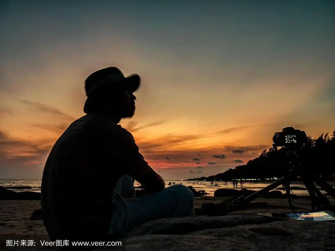 黄昏和日落的海边,有个男人在拍照