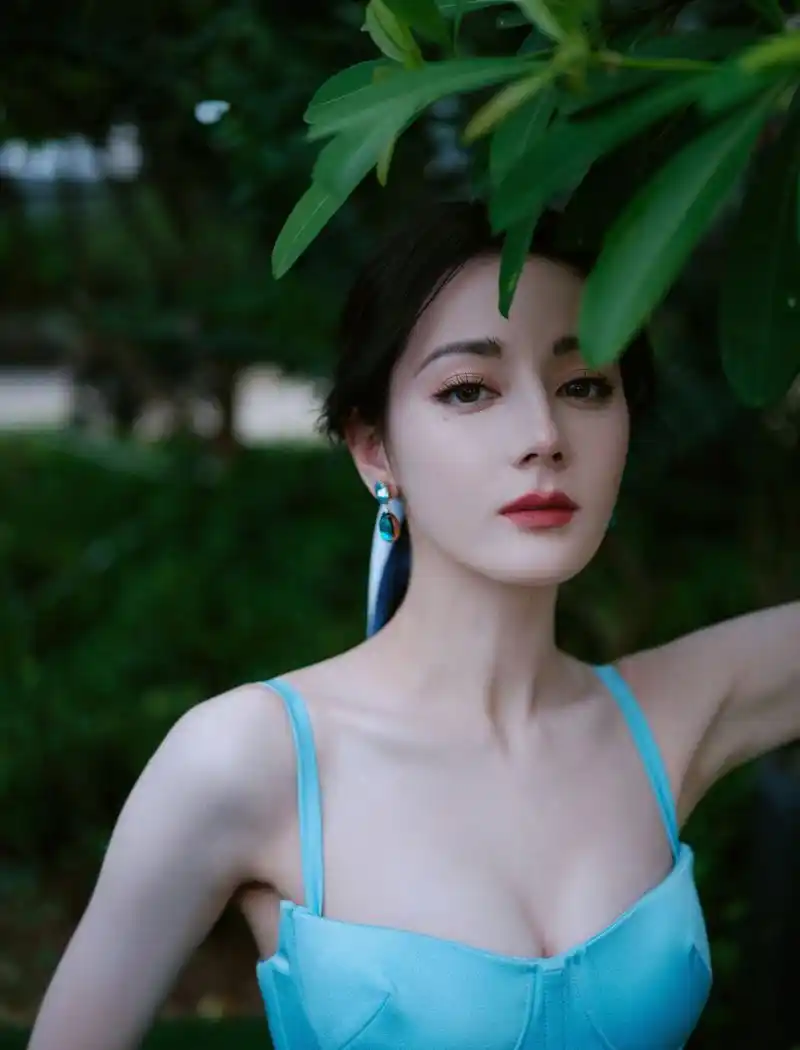 迪丽热巴的美照,身穿一件蓝色吊带裙,裙子的颜色与她的肤色相得益彰
