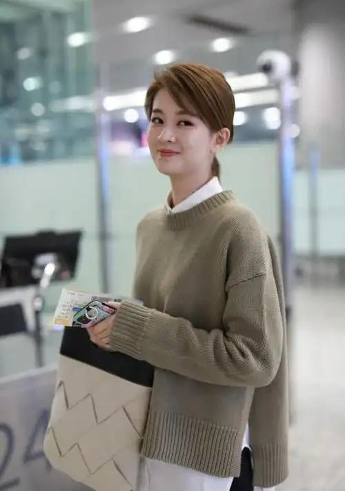 乔欣叠穿走机场,针织衫号小了不够长,内搭长出一大截
