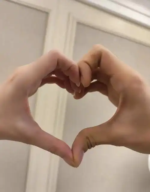 金莎和男友一起伸手比心,显然左边白嫩,指甲稍长的是金莎的手,右边的