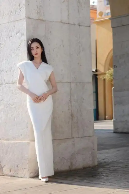 刘诗诗身着一袭v领白色连身长裙,展现出她的优雅气质和完美身材线条