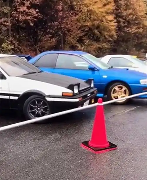 2台丰田ae86停户外侧面贴藤原豆腐坊日文供过往路人拍照