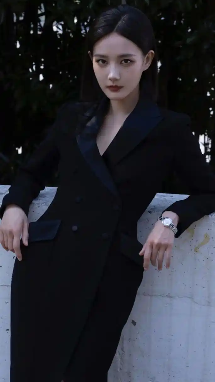 李一桐一头齐肩短发,穿着一套黑色西装,并戴上了墨镜.