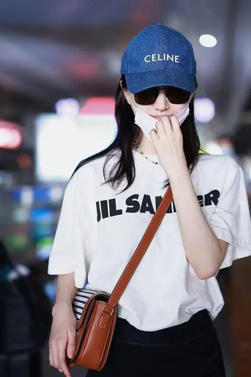 挎包上印着横条纹图案,时尚耐看~2021年7月13日,上海,景甜机场街拍