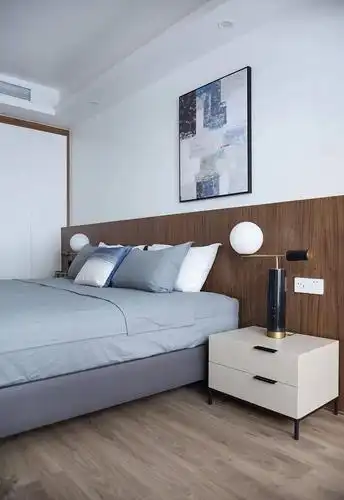 床头墙墙脚加入木饰面靠背,布置灰色皮艺床与床单,带来一个简约舒适的