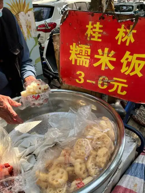 沿着玮武菜市往下走,来到南宁二中门口附近,老爷爷推着三轮车摆摊