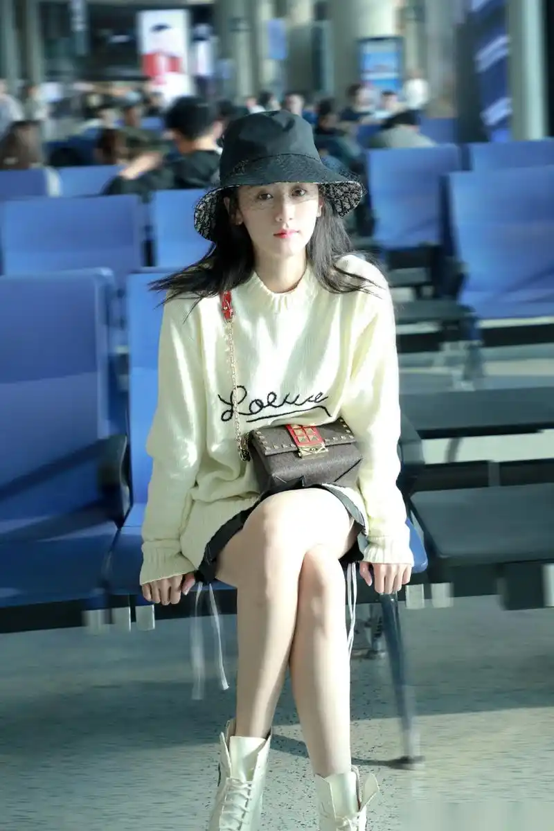 袁冰妍身着白色毛衣搭配黑色抽绳短裙,"下半身失踪"大法加马丁靴突出