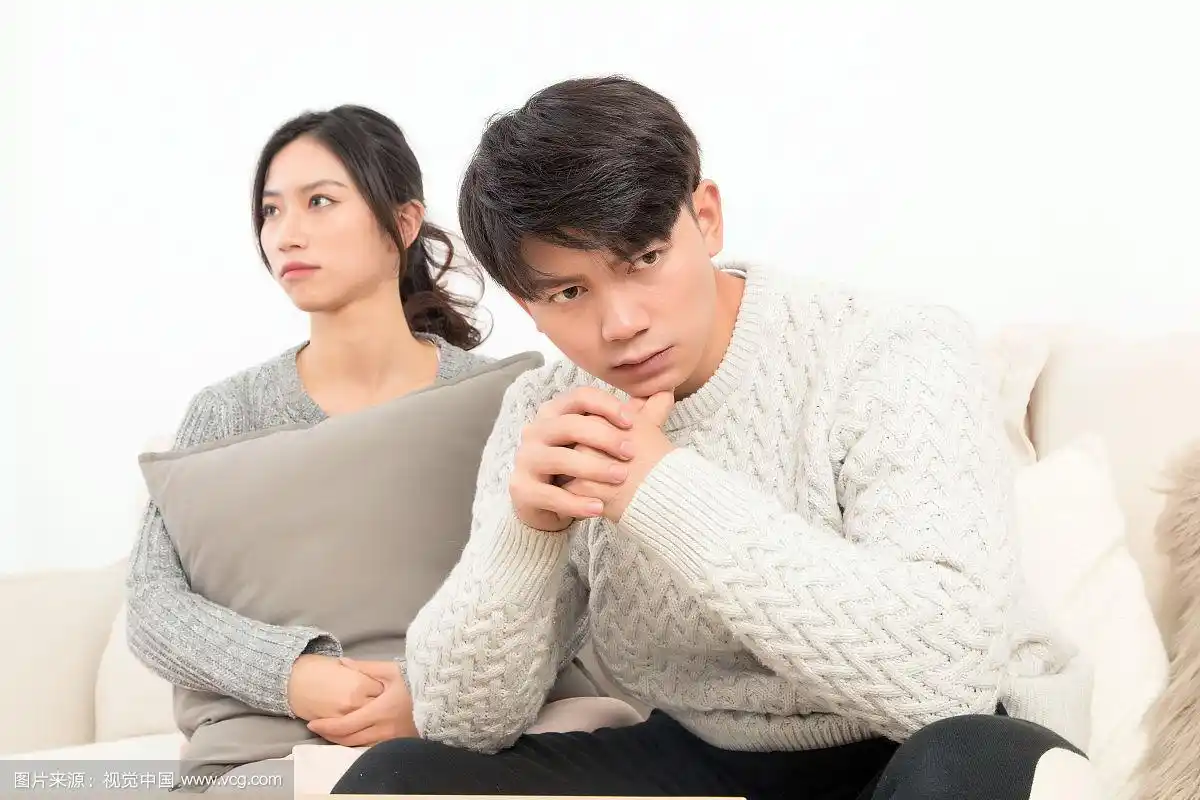 一对漂亮的亚洲年轻情侣坐在沙发上吵架