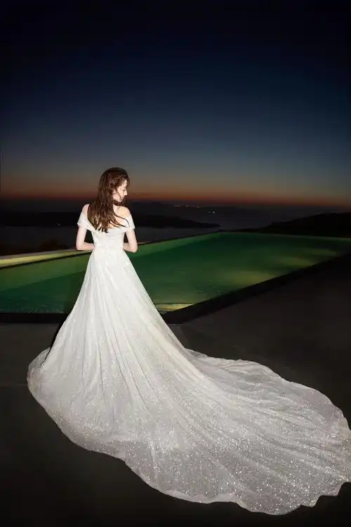 迪丽热巴穿婚纱拍大片 夕阳下香肩半露笑容甜美