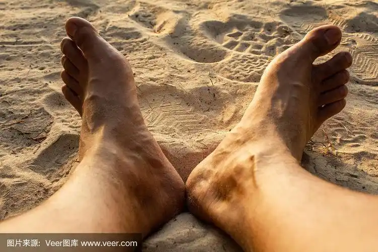 男人脚踩在海沙上,在海边度假,暑假.