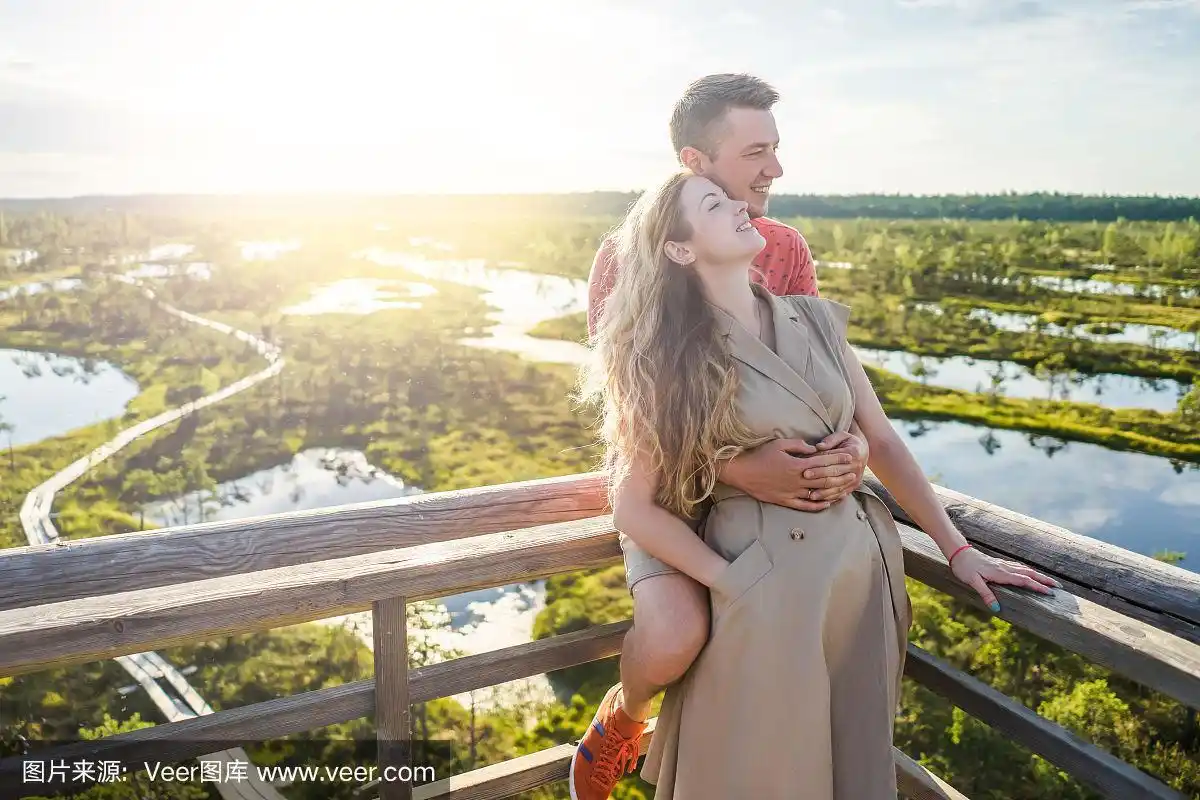 这是一对恩爱的情侣在木桥上拥抱的照片