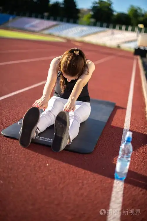 女运动员在阳光明媚的日子户外做柔韧性练习