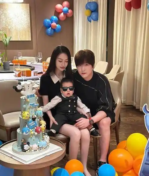 合影中一位女子抱着小孩,白冰则依偎在两人身边,身边还有一个巨大的