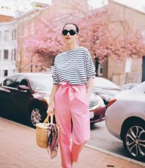 对于肤色不是很白皙的女性来说选择用粉色的裤子来搭配整体的造型