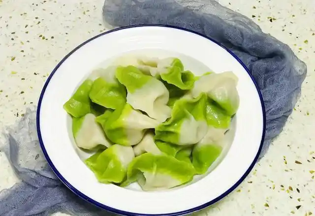 11.煮熟的彩色饺子装在盘子里上桌食用,喜欢醋和辣椒的可以配上诈些