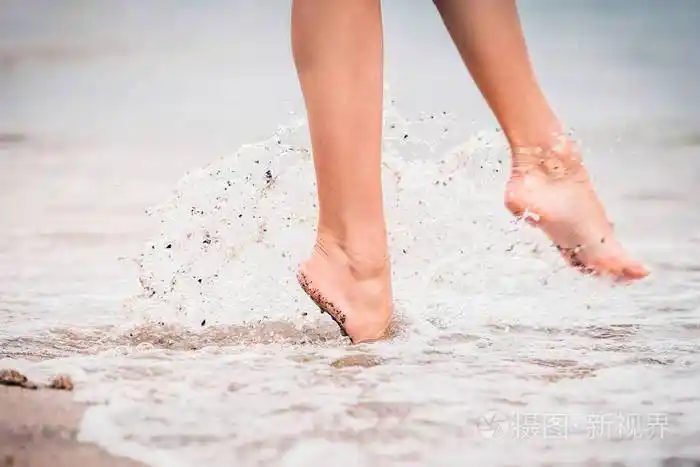 夏天在海上的女孩赤脚进入水中