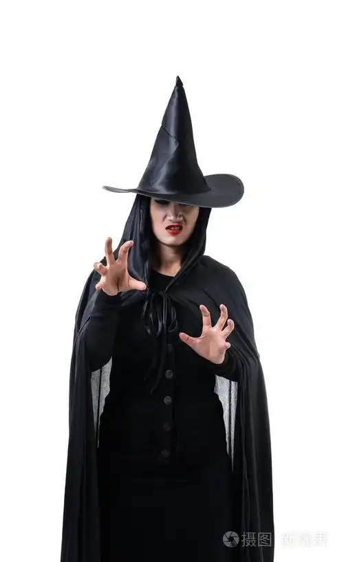 在黑色可怕的女巫万圣节服装的肖像站在白色背景的帽子和喃喃的咒语与