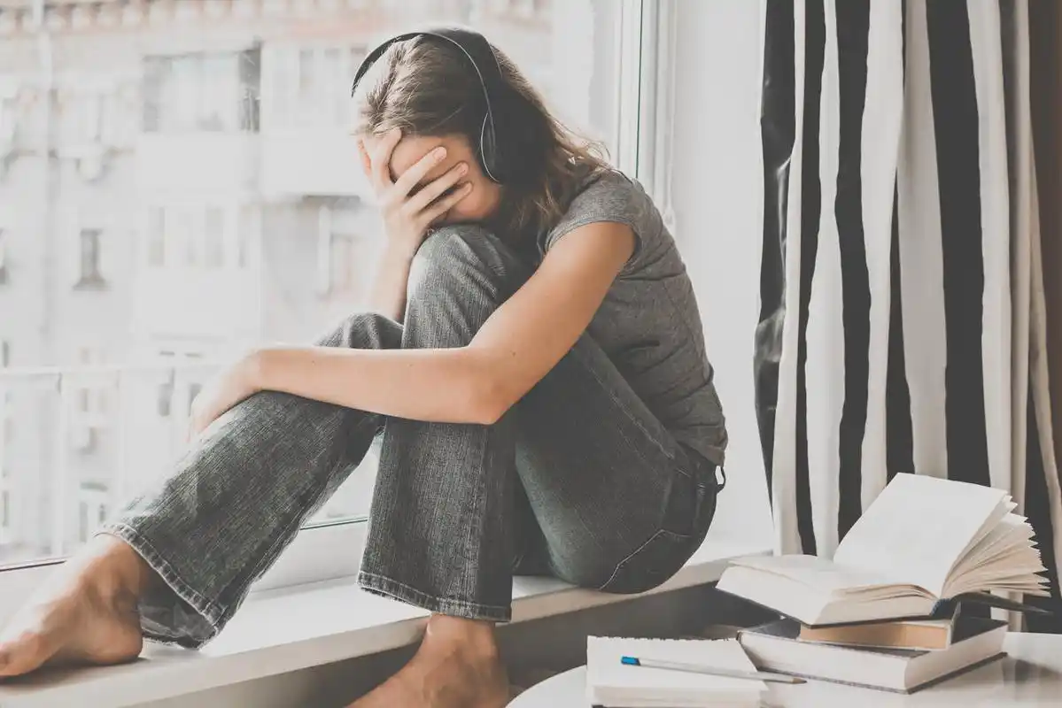 一个悲伤的少女正坐在窗台上