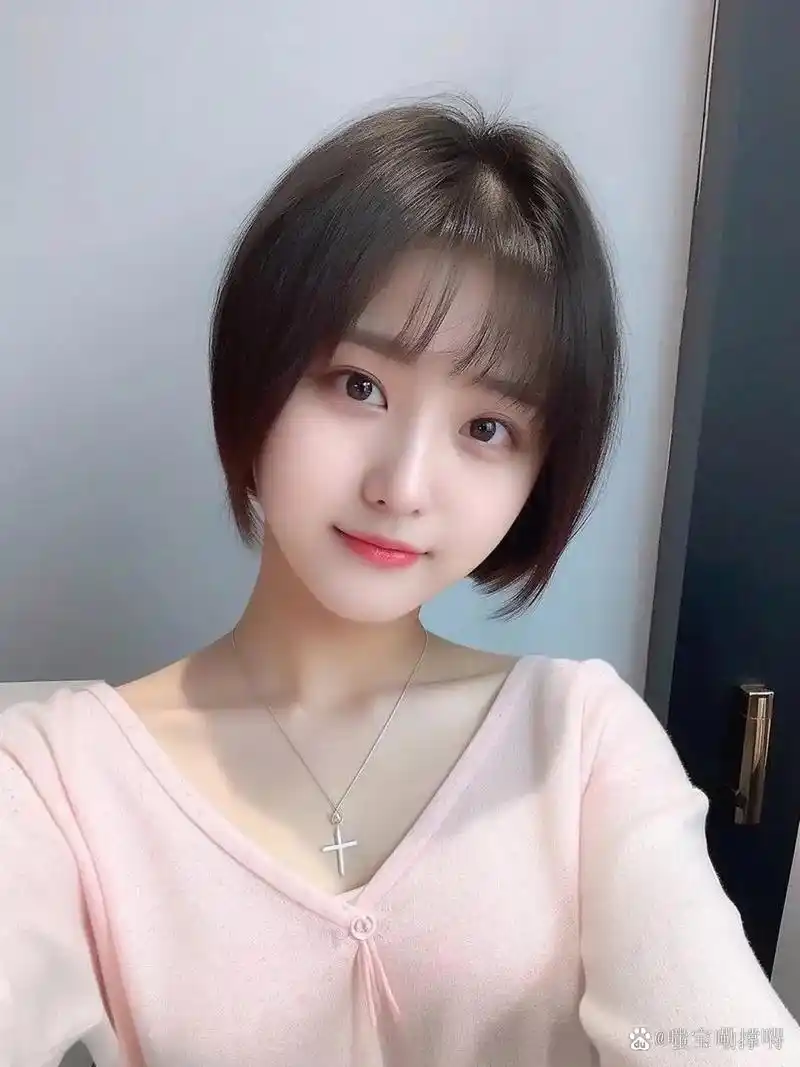 她身穿粉色衣裳,短发齐耳,眼中闪烁着光芒.