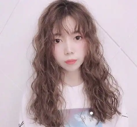 让小脸的女生看起来更加大气,女生空气刘海烫发发型顺着肩膀来打理,发