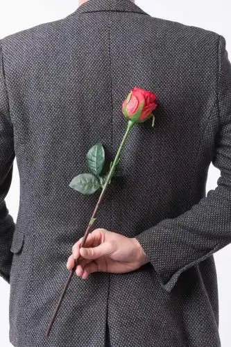 手拿玫瑰花的男性背影