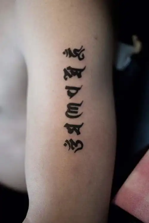 王先生左臂佛家朴实六字箴言纹身图案