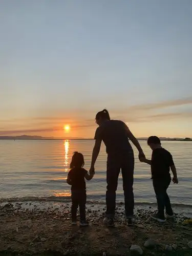 夕阳西下的湖边,妈妈两手拉着我们,妈妈的背影好美好美!好温柔!