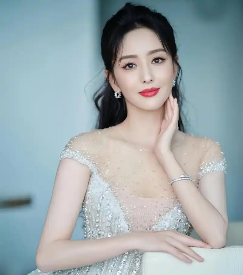 佟丽娅身穿白色闪钻仙女纱裙,身姿曼妙,对着镜头微微露笑,凭栏眺望