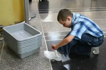 图文:小男孩在脱鞋准备进行安检