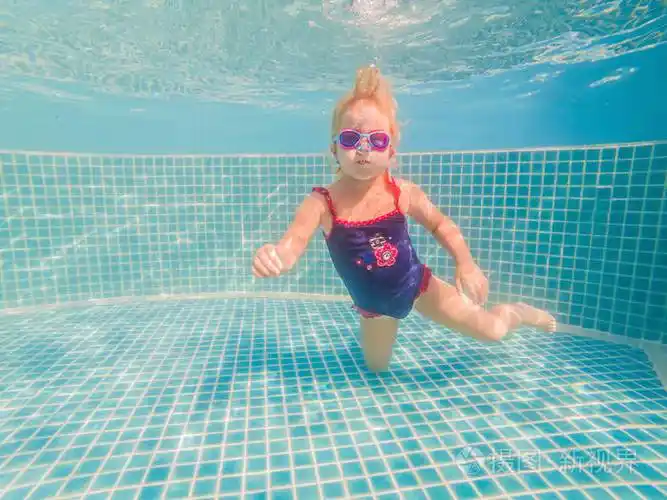 水上公园里的小女孩在水下游泳微笑着