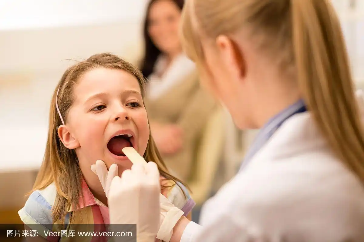 儿科医生检查一个小女孩的喉咙