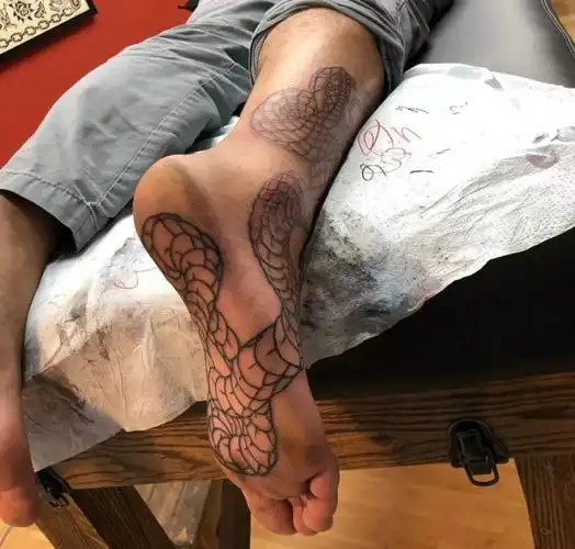 延伸到脚底板的设计是够新颖,由脚踝处的纹身开始,对美学一定有着较高