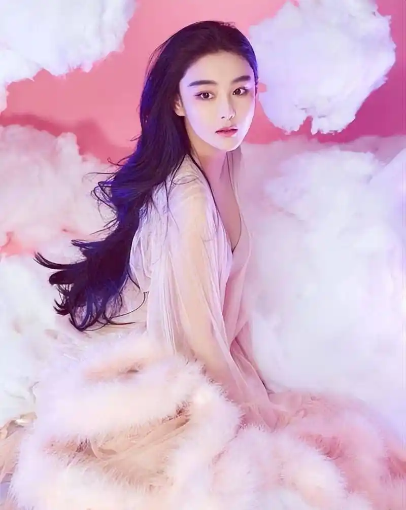 张馨予穿闪片粉裙美丽迷人,蜷缩在沙发上摆拍轻松惬意