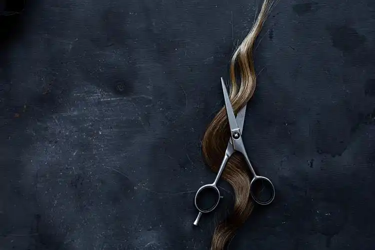 剪刀在灰色纹理背景上有一绺头发,剪头发图片下载