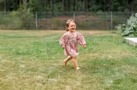 童年,休闲和人的概念-赤脚在草地上奔跑的快乐小女婴.女孩美女