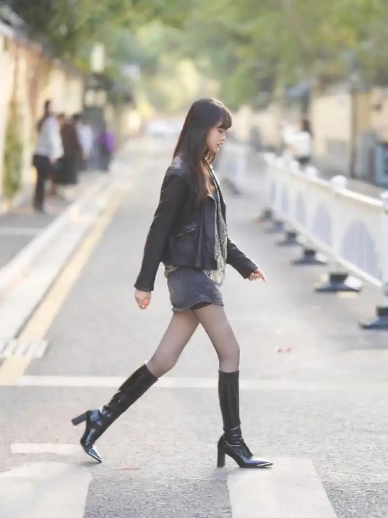 经典的穿搭长筒靴配丝袜,完美的展现了美女窈窕的身材
