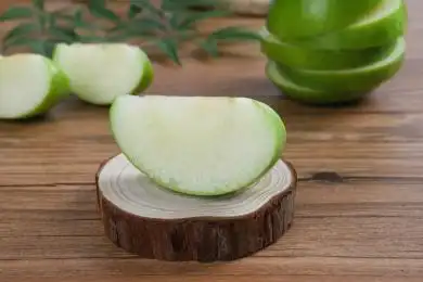 放在木纹背景木墩上切开的青苹果