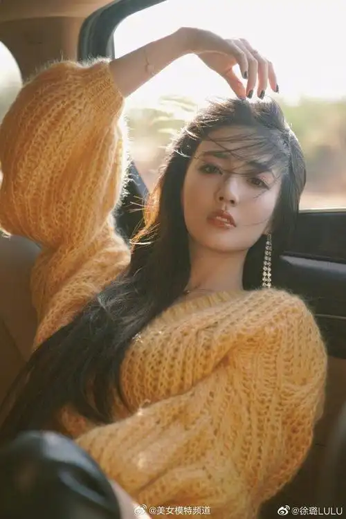 徐璐穿黄色毛衣置身车内拍片长发随风舞动眼神迷人