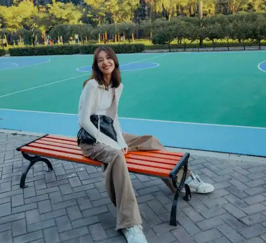 刘雯坐篮球架下秀大长腿,穿白色开衫露纤纤细腰,对镜微笑显温柔