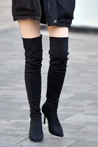 黑色的尖头细跟过膝长靴,搭配一款黑色羽绒服,时髦又很保暖显高