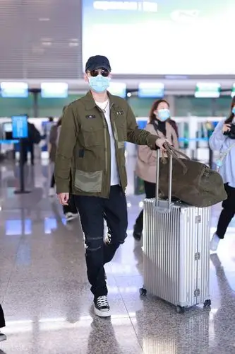 欧豪身穿军绿色外套仿佛特种兵,独自拎大包小裹赶行程