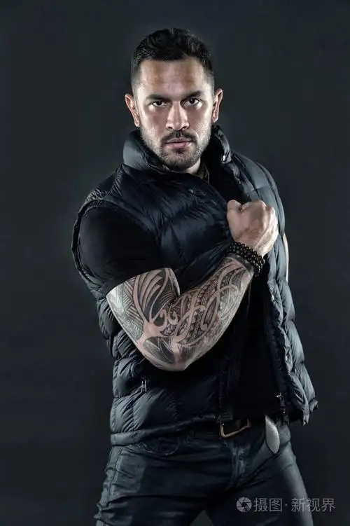 在强壮的手臂皮肤上有纹身的男人.时尚男子气概的信心和魅力.