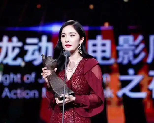 成龙动作电影周之夜杨幂封后,杨幂身穿一袭酒红色长裙登台领奖,优雅动