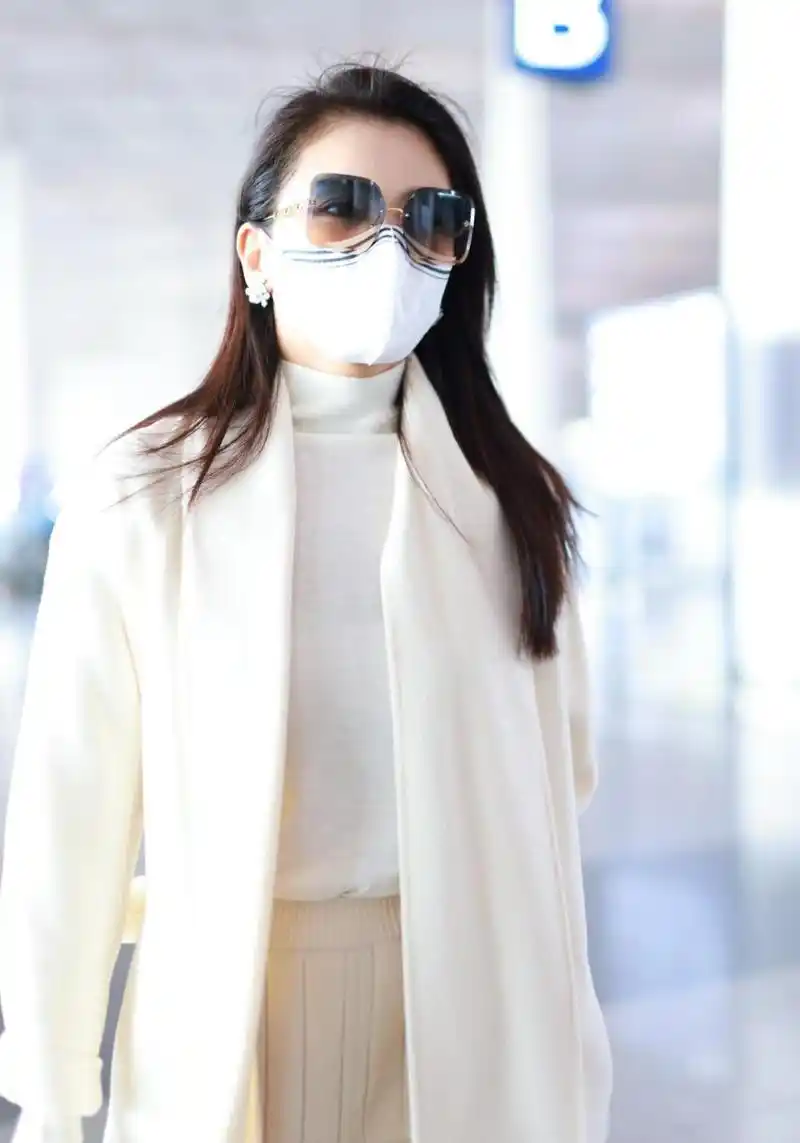 刘涛机场街拍,一身奶白色套装端庄优雅.