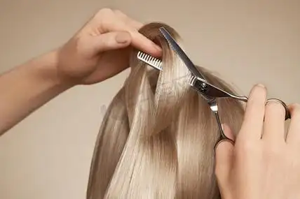 理发师用剪刀剪长长的金发.头发秀发