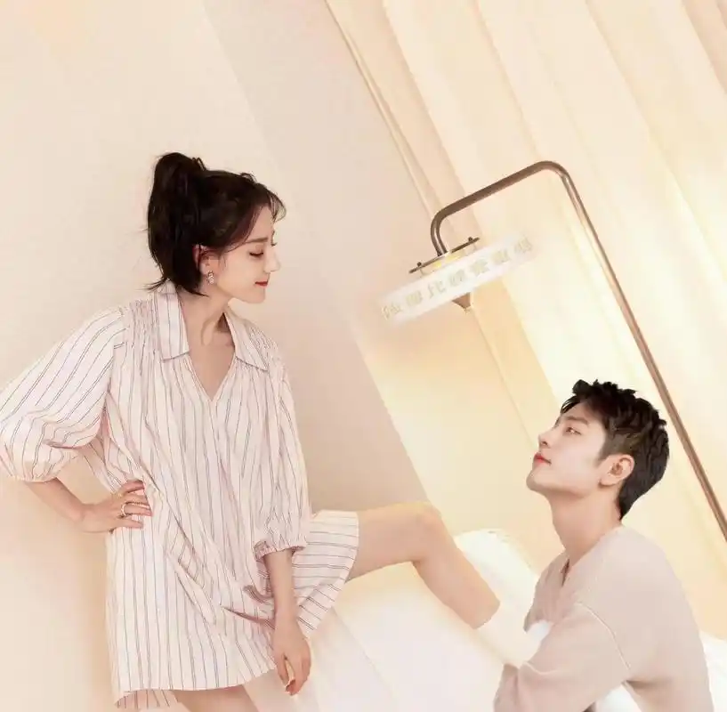 迪丽热巴穿着性感,低着腰,肖战搂着迪丽热巴的脚坐在那里!